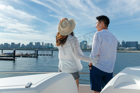 浪漫的青年夫妇站在游艇甲板上