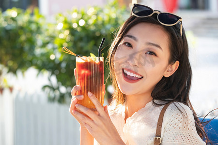 夏日清新饮品摄影照片_快乐的青年女人端着夏日饮品