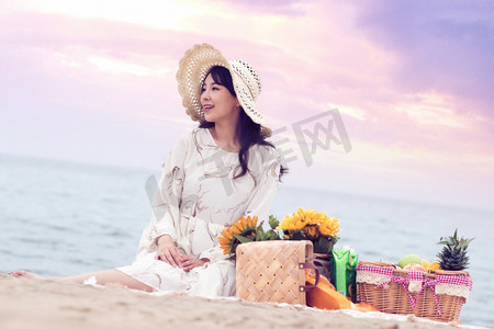 快乐的青年女人坐在沙滩上