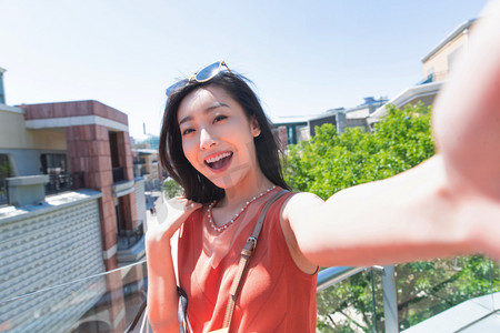 女人逛街摄影照片_户外逛街自拍的青年女人