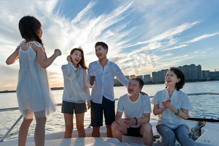 夕阳下在游艇上的快乐一家人