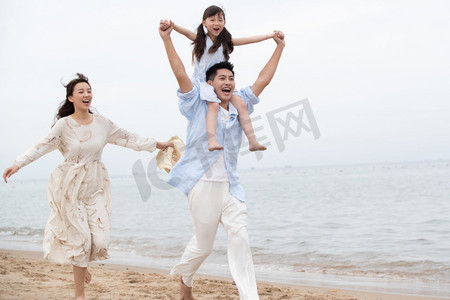 幸福的一家三口在海边玩耍