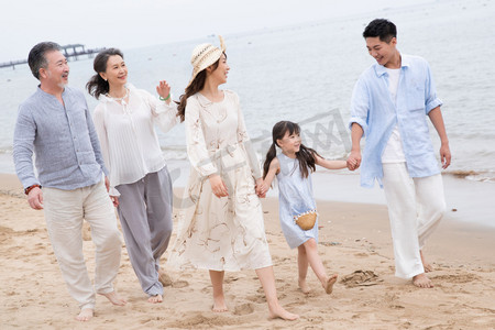 海滩游玩摄影照片_快乐的一家人在海滩上散步