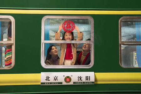幸福家庭剪纸摄影照片_一家三口在火车上贴福字