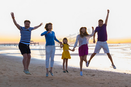 在海边欢呼跳跃的幸福家庭