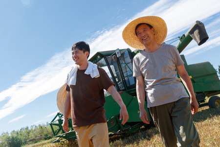 农业机械化摄影照片_农田里实现机械化收割的农民