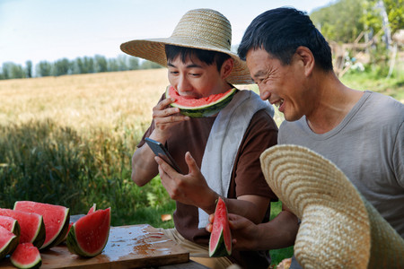 农民在田地旁休息吃西瓜
