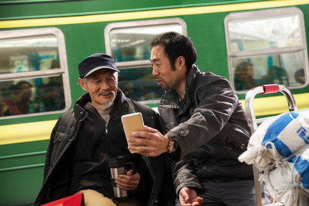 春运视频摄影照片_在火车站台上看手机的旅客