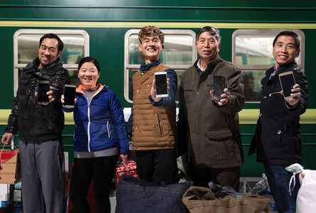 背包展示摄影照片_站在火车月台上展示手机的旅客