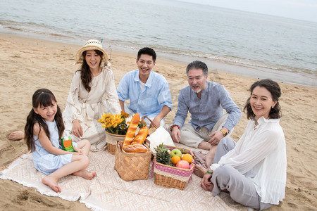 食品海边摄影照片_在海边度假的一家人野餐