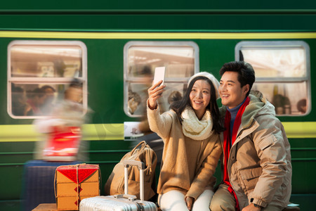 中国红摄影照片_在火车站台上的青年情侣看手机