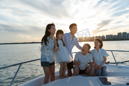 夕阳下在游艇上的快乐一家人
