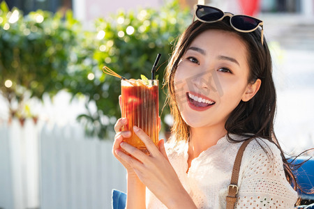 夏日清新饮品摄影照片_快乐的青年女人端着夏日饮品