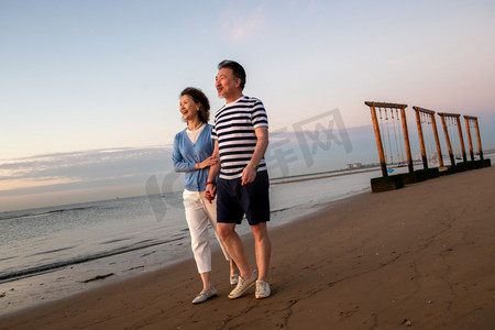 海边晚霞摄影照片_老年夫妇在海边散步