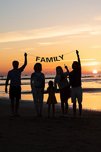 海滩游玩摄影照片_在海边度假的快乐家庭