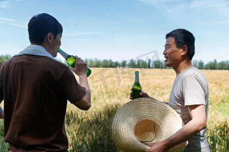 农民在麦田旁喝啤酒