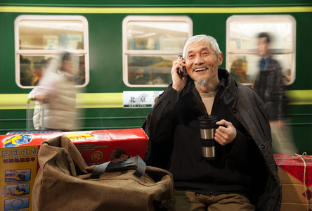 春节老人摄影照片_在火车站台上打电话的老人