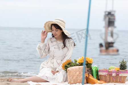 快乐的青年女人坐在沙滩上