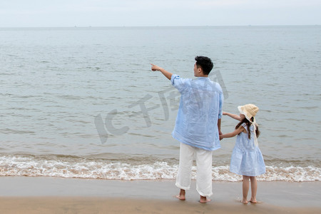 夏日海边沙滩玩耍摄影照片_快乐父女在海边玩耍