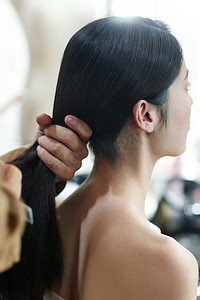 梳头发的人摄影照片_年轻女人做头发