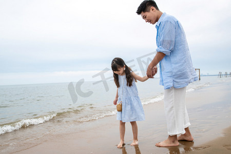 海滩游玩摄影照片_快乐父女在海边玩耍