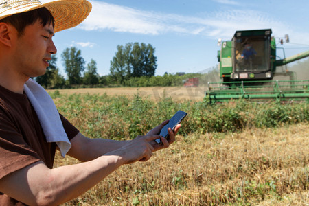 科技耕地摄影照片_农民站在麦田里使用手机