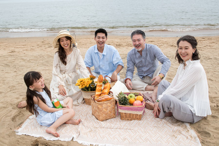 水果摄影照片_在海边度假的一家人野餐
