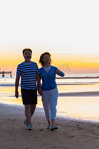 海滩游玩摄影照片_老年夫妇在海边散步