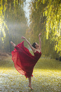 活力红色摄影照片_穿红色裙子的青年女人在户外跳芭蕾舞