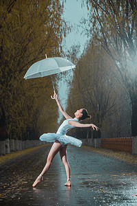 拿着雨伞的青年女人跳芭蕾舞