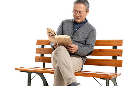 坐在长椅上的老人看书