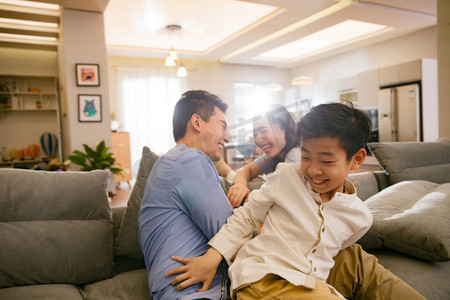 孩子在客厅玩耍摄影照片_幸福家庭在客厅
