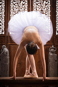 青年女人在中式古典门前跳芭蕾舞