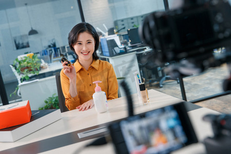 疑惑真人摄影照片_青年女人在线直播销售化妆品