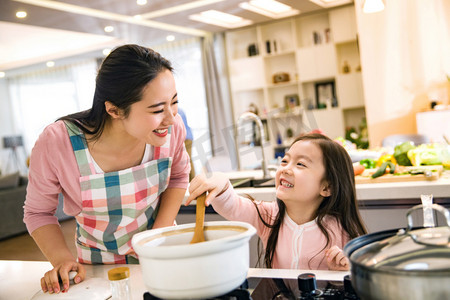 砂锅黄花鱼摄影照片_年轻妈妈和女儿在厨房