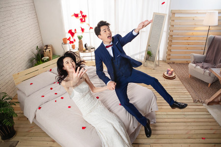 花瓣动态摄影照片_兴奋的新婚夫妇倒在床上