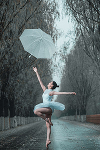 拿着雨伞的青年女人跳芭蕾舞