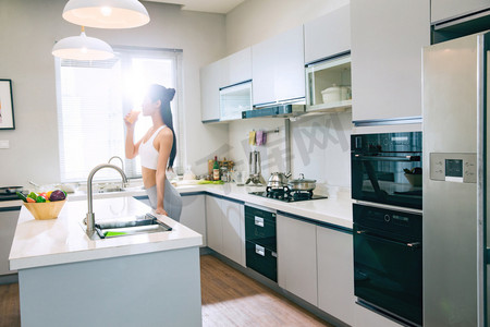 食物清新摄影照片_穿着运动装的青年女人在厨房