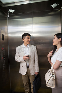 男女图摄影照片_商务青年男女乘电梯