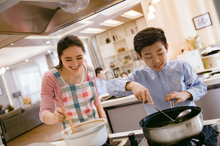 学生做饭摄影照片_年轻妈妈和儿子在厨房