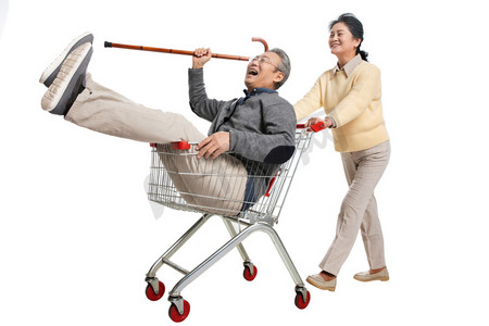 快乐老人推着坐在购物车里的老伴