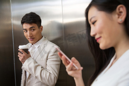 乘电梯摄影照片_商务青年男女乘电梯