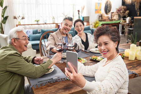 聚会自拍聚会摄影照片_聚会时中老年人拿手机自拍