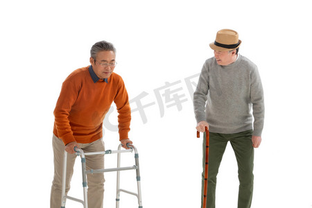 老年人瘫痪摄影照片_两位老人拄着拐杖聊天