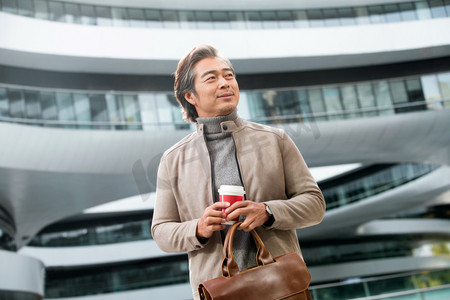 亚洲杯摄影照片_商务男士拿着咖啡杯去上班