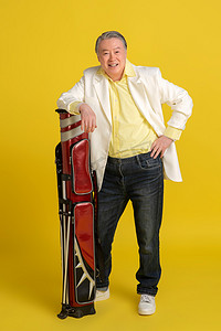 高尔夫球包摄影照片_拿着高尔夫球包的快乐老年人