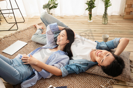 快乐情侣躺在地毯上享受午后时光
