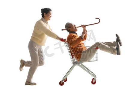 老人购物车摄影照片_快乐老人推着坐在购物车里的老伴