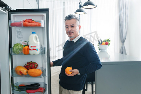 冰箱内的水果摄影照片_中老年男士开冰箱拿水果