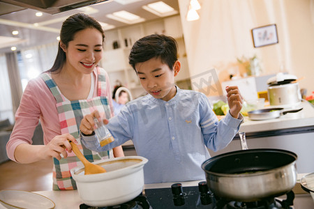 学生做饭摄影照片_年轻妈妈和儿子在厨房